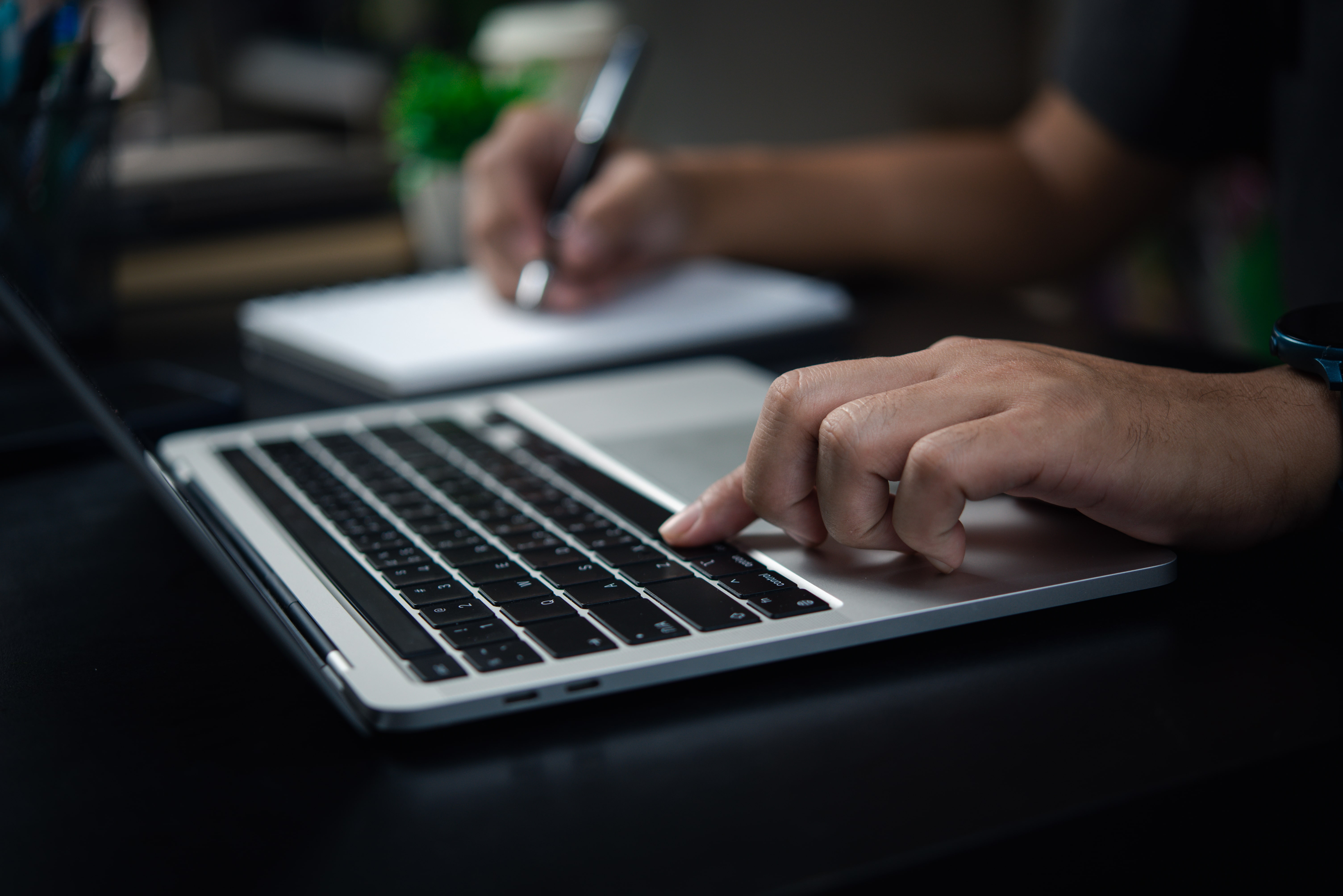 Hands typing on laptop